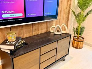 a dresser with a tv on top of it at Goldcrest Lahore in Lahore