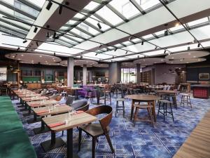 ワルシャワにあるMercure Warszawa Ursus Stationの木製のテーブルと椅子のあるダイニングルーム