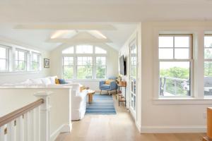 un salon avec des murs et des fenêtres blancs dans l'établissement Gorgeous Architectural Home w Water Views, à Eastham