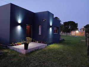 a blue house with a table in the grass at El Dorado in Mar del Plata +4 photos