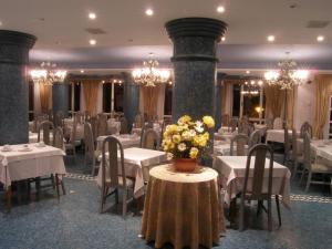 a restaurant with white tables and chairs and flowers at Hotel Torre Cristina in Noja