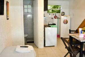 une cuisine avec un réfrigérateur blanc et une table dans l'établissement Pousada pantera do rosa, à Imbituba 29 autres photos