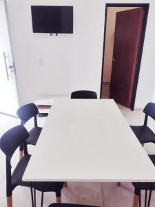 a meeting room with a white table and chairs at Nuestras raíces 1 in Villa Carlos Paz