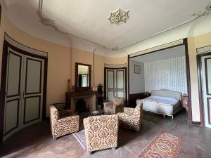 un soggiorno con letto, sedie e specchio di Chateau d'Albon - Saint Andre d'Apchon a Saint-André-dʼApchon Altre 9 foto