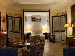 una camera d'albergo con un letto, un divano e delle sedie di Chateau d'Albon - Saint Andre d'Apchon a Saint-André-dʼApchon