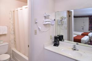 a bathroom with a sink and a mirror at Americas Best Value Inn Wildersville in Wildersville +42 photos