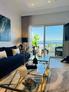 ein Wohnzimmer mit einem blauen Sofa und einem Glastisch in der Unterkunft Paradiso in Sidi Bou Saïd