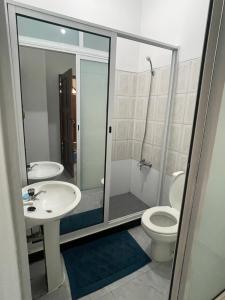 a bathroom with a toilet and a sink and a shower at Quarto- Espaço Casa Mendes in Praia