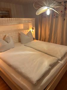 里茨勒恩Mazot - ganzes Ferienhaus的一张铺着白色床单和枕头的大床