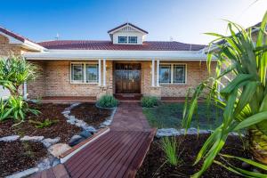 a house with a wooden walkway in front of it at Crystal Palms - Oceanstays - Riverside in Yamba