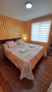 a bedroom with a large bed with pink pillows at Casa en Puerto Montt in Puerto Montt