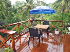 una terrazza in legno con tavolo e ombrellone di Master's Homestay a Suva