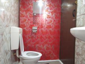 un bagno con un water e una parete rossa di Master's Homestay a Suva Altre 27 foto