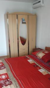 a bedroom with a large bed with a red blanket at Apartmani kod Rade in Pakoštane