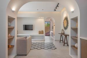 een woonkamer met een televisie en een bank bij Avaton Boutique Suites in Vrachonisída touArchangélou