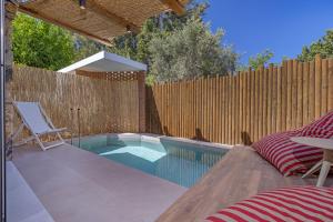 een zwembad in een achtertuin met een houten hek bij Avaton Boutique Suites in Vrachonisída touArchangélou