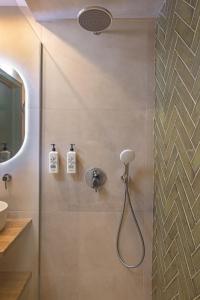 een douche met een douchekop in een badkamer bij Avaton Boutique Suites in Vrachonisída touArchangélou