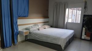 马卡帕Casa TDM 3的一间卧室,里面有一张床和一扇窗户。