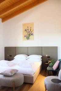 a bedroom with a large white bed and two chairs at Tenuta Tommasi - Relais Bacco in Caorle