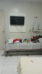 马卡帕Casa TDM 3的一间卧室，有一张床，墙上有一台电视