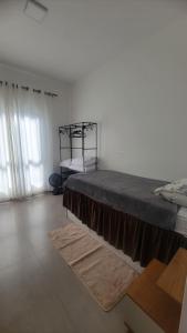 ein Schlafzimmer mit einem großen Bett und einem Bettrahmen in der Unterkunft Jenni's House in Itapoa + 3 Fotos