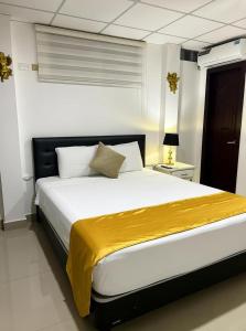 Un dormitorio con una cama grande con una manta amarilla. en The Royalty Lite, en Guayaquil 6 fotos más
