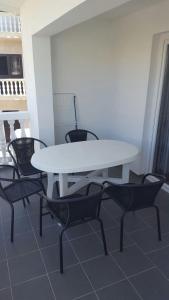 a white table and chairs in a room at Apartmani kod Rade in Pakoštane