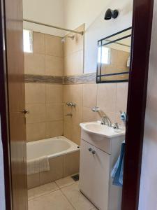 een badkamer met een bad en een wastafel en een ligbad bij Casa en Cabalango in Cavalango