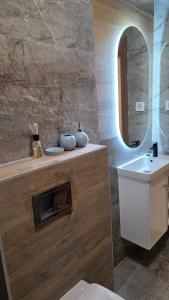 un bagno con lavandino, WC e specchio di Green Apartman a Veternik