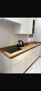 a kitchen with white cabinets and a counter top at استديو مودرن فندقي in Al Kharj