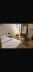 a bedroom with a bed and a desk and a chair at استديو مودرن فندقي in Al Kharj