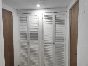 a closet with white shutter doors in a room at Apartment on Margarita Island edif Lagunablanca Apto 1201 in Porlamar