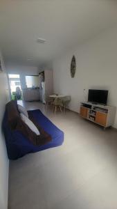 イタポアにあるJenni's Houseのベッド、テレビ、テーブルのある寝室