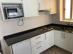 a kitchen with white cabinets and a microwave at Casa Emilia in Talayuelas