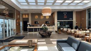 eine Lobby eines Restaurants mit einem Tisch und Stühlen in der Unterkunft Flat Sofisticado no Jade Hotel Home Office in Brasilia