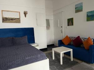 a living room with a blue bed and a couch at Studio tres calme Quartier administratif Rabat in Rabat
