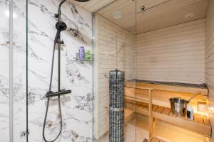 a shower in a sauna with a glass wall at Lapland Apartment in Rovaniemi +45 photos