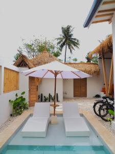 un patio avec une table, des chaises et un parasol dans l'établissement Alboran Villa Gili Air - Private Pool, à Gili Air