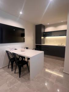 cocina con mesa blanca y armarios negros en Catalina Hotel, en Yerba Buena