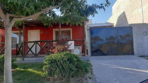 a red house with a gate in front of it at Armonía y plenitud in Trelew