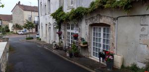 ein Gebäude mit Blumen an der Straßenseite in der Unterkunft La Belle Maison in Piégut-Pluviers