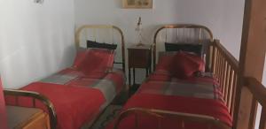 2 Betten in einem Zimmer mit roter Bettwäsche in der Unterkunft La Belle Maison in Piégut-Pluviers