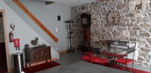 Zimmer mit einer Uhr an einer Steinmauer in der Unterkunft La Belle Maison in Piégut-Pluviers