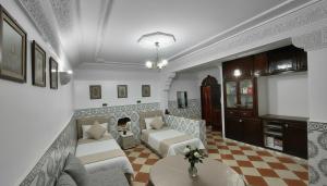 ein Wohnzimmer mit 2 Betten und einem Kamin in der Unterkunft Riad Imperial Atlas in Meknès