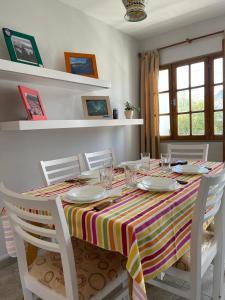 a dining room table with a striped table cloth at Rosa Mosqueta Esquel in Esquel