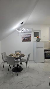 a dining room with a table and chairs at Flower Apartman in Veternik