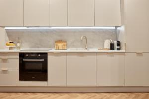 a kitchen with white cabinets and a sink at Apartament Hugo - Stare Miasto - Garaż Gratis !!! in Elblag
