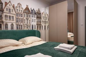 a bedroom with a green bed with a large window at Apartament Hugo - Stare Miasto - Garaż Gratis !!! in Elblag
