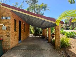 Una entrada a un edificio de ladrillo con techo. en Tropic Oasis by Charlesworth, en Coffs Harbour