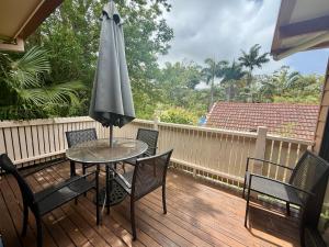 Un patio con una mesa y sillas y una sombrilla. en Tropic Oasis by Charlesworth, en Coffs Harbour 5 fotos más